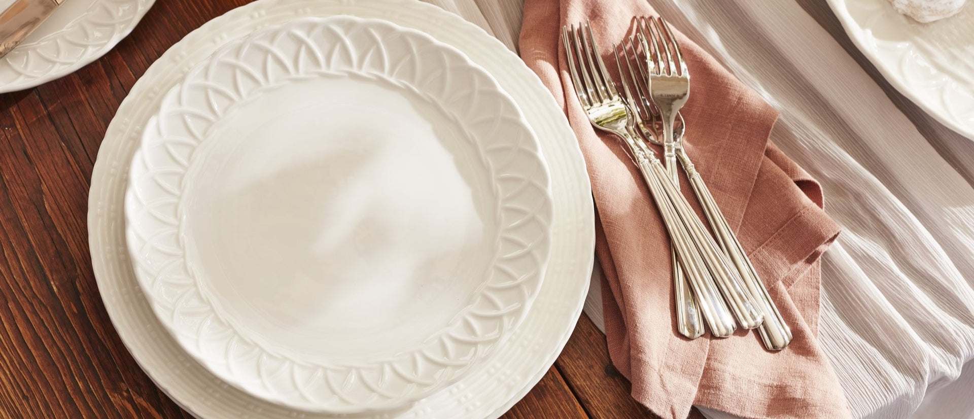 White dinner plates and forks on a napkin
