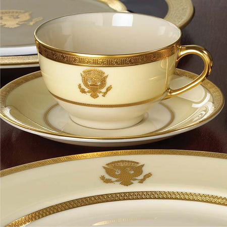 Cream teacup and plate featuring the gold Presidential Seal and gold rims.