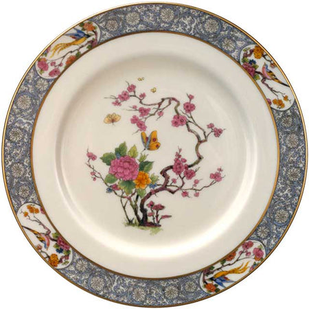 White porcelain plate with a blue patterned border and a central design of pink blossoms, butterflies, and birds.