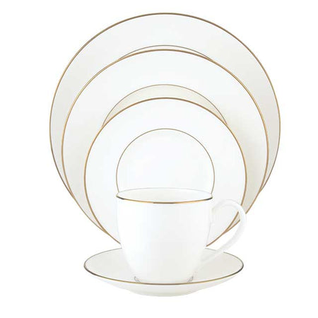 Formal white porcelain dinnerware set including plates, a teacup, and a saucer with a thin gold rim.