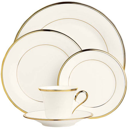 Cream porcelain dinnerware set with thin gold rims.