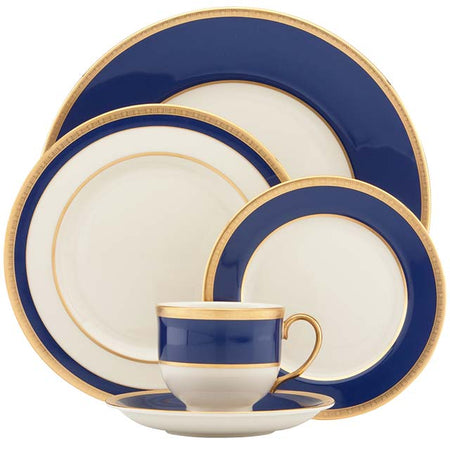 Cream dinnerware set with wide navy blue borders and gold rims.