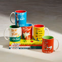 Set of Dr. Seuss-themed mugs and books on a gray background