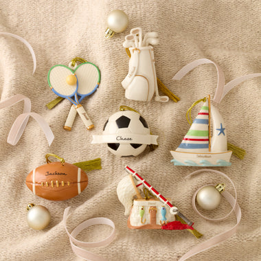 Collection of sports-themed Christmas ornaments on a textured surface