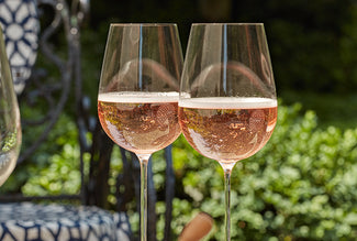 Two glasses of rosé wine with a blurred outdoor background